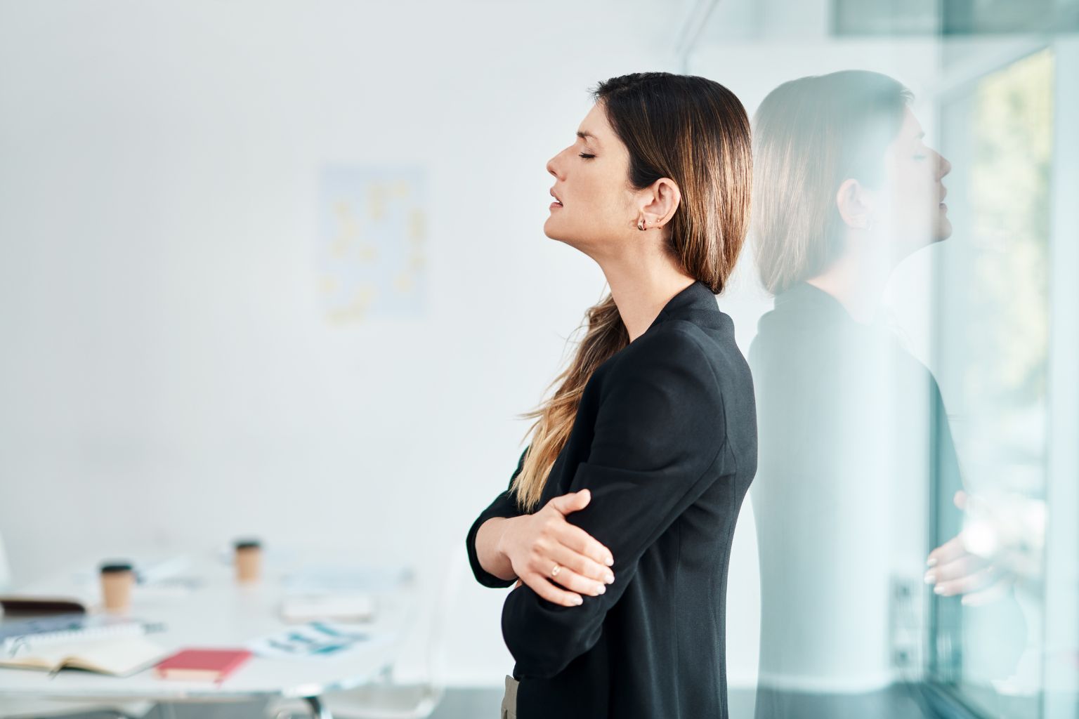 Woman standing quietly by a window, representing sudden muffled hearing concerns